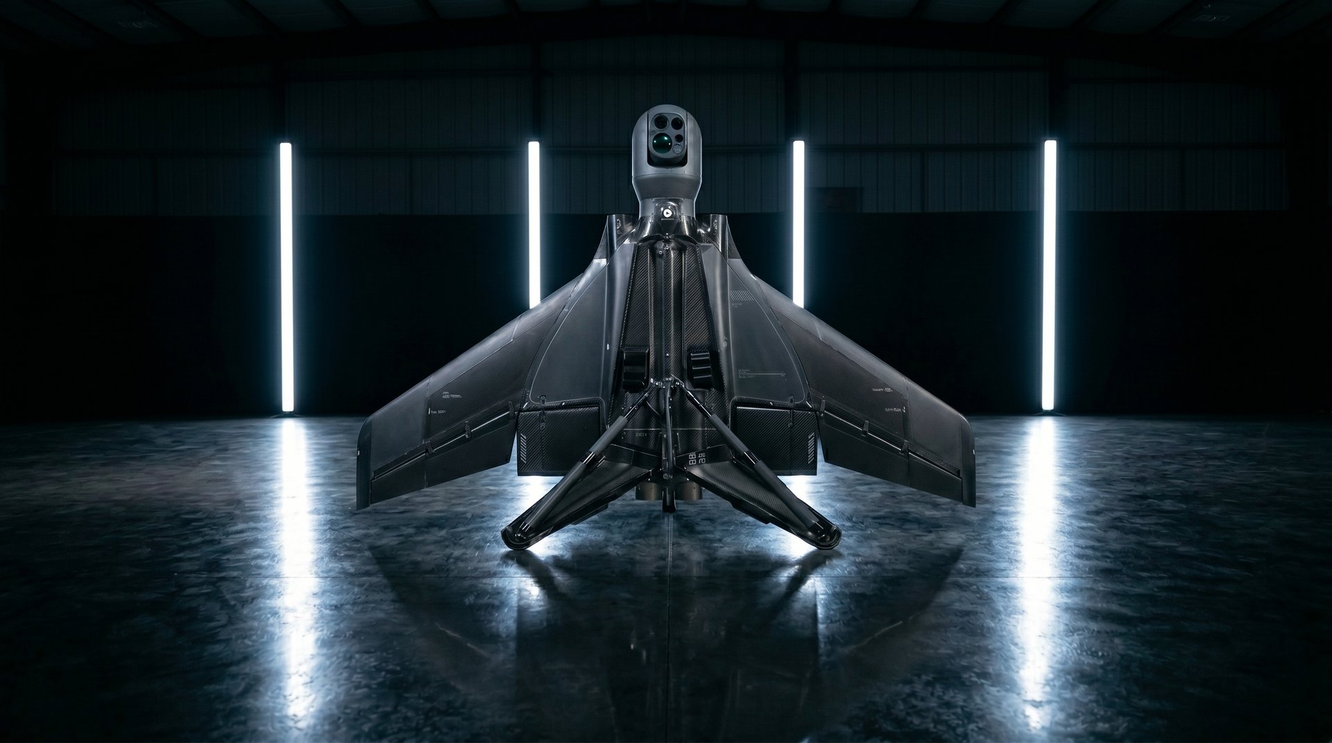 Rear three-quarter view of the Varn Gungnir AI strike drone with a top-mounted sensor turret and swept delta wings, parked in a hangar lit by vertical LED strips.